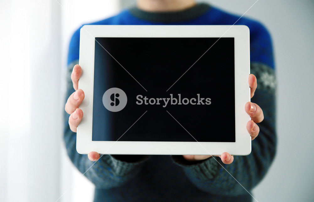 Closeup portrait of a male hands showing tablet computer screen