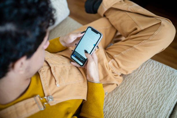 Portrait of young gay man using smart phone at home