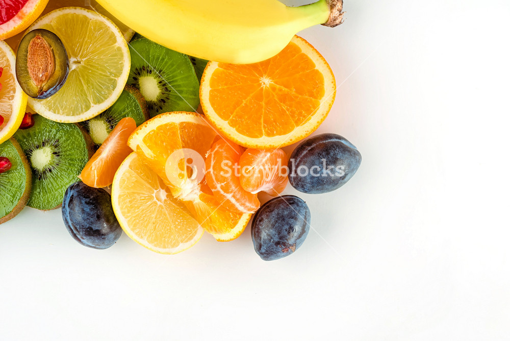 Top view of fresh juicy fruits and citruses over white background