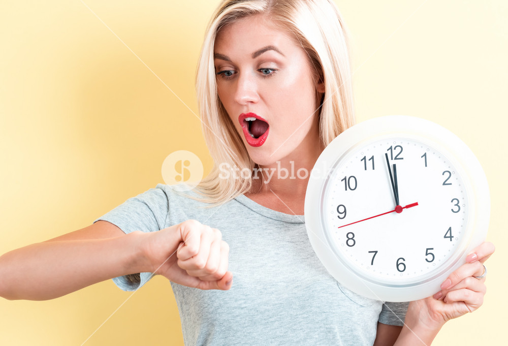 Woman holding a clock nearing midnight