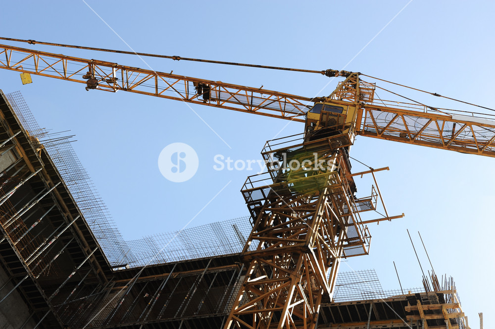 Buildings under construction and cranes under a blue sky